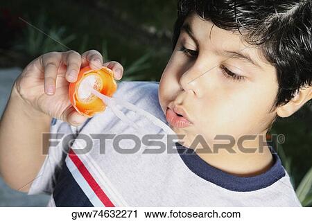 Close-up of a boy blowing bubbles with a bubble wand View Large Photo Image Stock Image - Close-up of a boy blowing bubbles with a bubble wand. Fotosearch