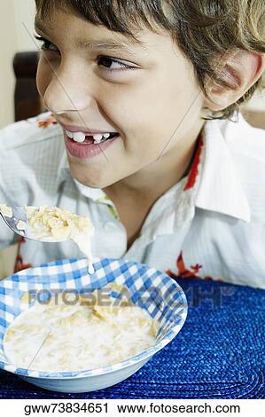 Close-up of a boy eating corn flakes and smiling View Large Photo Image Stock Image - Close-up of a boy eating corn flakes and smiling. Fotosearch