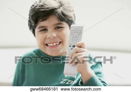 Close-up of a boy holding a remote control and smiling View Large Photo Image Stock Image - Close-up of a boy holding a remote control and smiling. Fotosearch