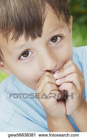 Close-up of a boy with his hands covering his mouth View Large Photo Image Stock Image - Close-up of a boy with his hands covering his mouth. Fotosearch