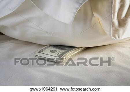 Close-up of a bundle of one hundred dollar bills on the bed View Large Photo Image Stock Image - Close-up of a bundle of one hundred dollar bills on the bed. Fotosearch