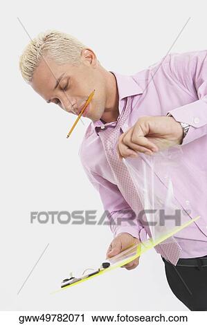 Stock Image - Close-up of a businessman holding a clipboard. Fotosearch
