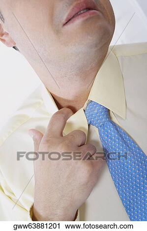 Close-up of a businessman pulling his collar View Large Photo Image Stock Image - Close-up of a businessman pulling his collar. Fotosearch