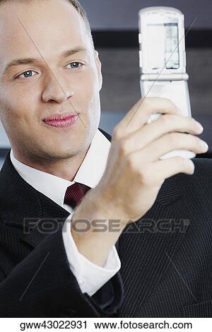 Stock Image - Close-up of a businessman taking his photograph with a mobile phone. Fotosearch