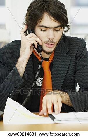 Close-up of a businessman talking on the telephone and reading a file View Large Photo Image Stock Image - Close-up of a businessman talking on the telephone and reading a file. Fotosearch