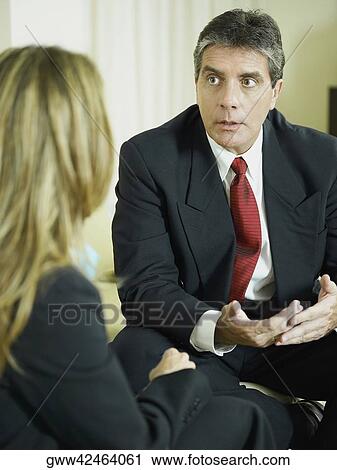 Close-up of a businessman talking to a businesswoman View Large Photo Image Stock Image - Close-up of a businessman talking to a businesswoman. Fotosearch
