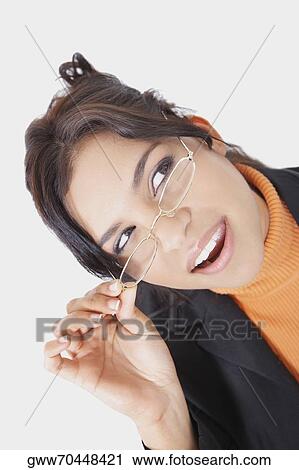 Close-up of a businesswoman adjusting her eyeglasses and looking up View Large Photo Image Stock Image - Close-up of a businesswoman adjusting her eyeglasses and looking up. Fotosearch