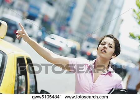 Close-up of a businesswoman hailing a taxi View Large Photo Image Stock Image - Close-up of a businesswoman hailing a taxi. Fotosearch