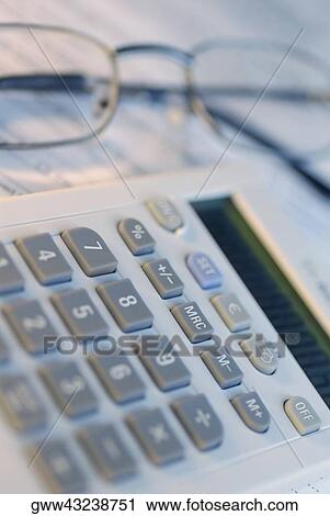 Stock Image - Close-up of a calculator with a pair of eyeglasses. Fotosearch