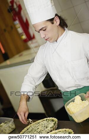 Close-up of a chef preparing food in a commercial kitchen View Large Photo Image Stock Image - Close-up of a chef preparing food in a commercial kitchen. Fotosearch