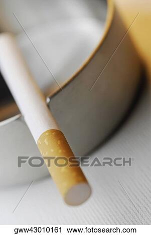 Close-up of a cigarette in an ashtray View Large Photo Image Stock Image - Close-up of a cigarette in an ashtray. Fotosearch