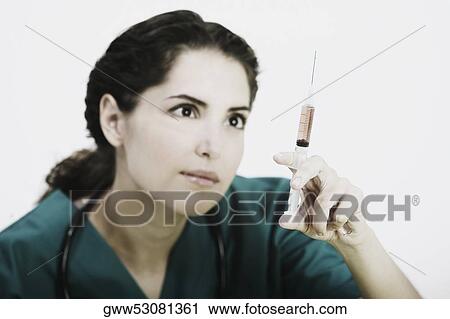 Close-up of a female doctor in scrubs with a syringe View Large Photo Image Stock Image - Close-up of a female doctor in scrubs with a syringe. Fotosearch
