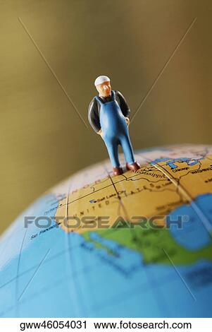 Close-up of a figurine on a globe View Large Photo Image Stock Image - Close-up of a figurine on a globe. Fotosearch