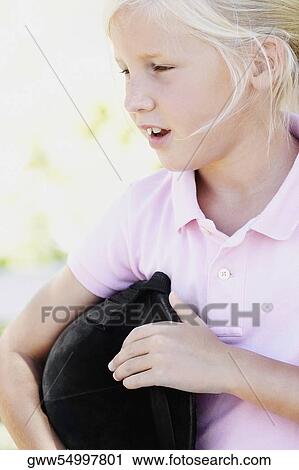 Close-up of a girl holding a riding hat View Large Photo Image Stock Image - Close-up of a girl holding a riding hat. Fotosearch