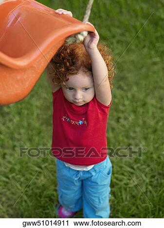 Stock Image - Close-up of a girl holding a rope swing. Fotosearch