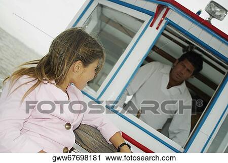 Close-up of a girl looking at her father in a motorboat View Large Photo Image Stock Image - Close-up of a girl looking at her father in a motorboat. Fotosearch