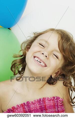 Stock Image - Close-up of a girl smiling with her eyes closed. Fotosearch