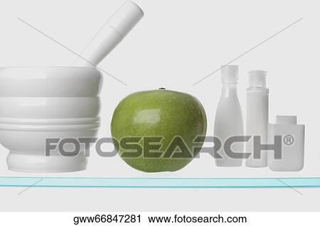 Stock Image - Close-up of a granny smith apple with mortar and pestle. Fotosearch