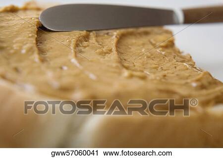 Close-up of a knife spreading peanut butter on a slice of bread View Large Photo Image Stock Image - Close-up of a knife spreading peanut butter on a slice of bread. Fotosearch