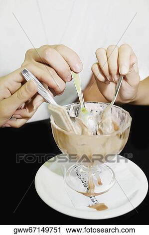Close-up of a man and two women sharing an ice-cream sundae View Large Photo Image Stock Image - Close-up of a man and two women sharing an ice-cream sundae. Fotosearch