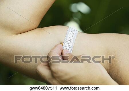 Close-up of a man measuring his biceps with a measuring tape View Large Photo Image Stock Image - Close-up of a man measuring his biceps with a measuring tape. Fotosearch