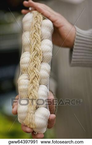 Close-up of a man's hands holding a packet of garlic View Large Photo Image Stock Image - Close-up of a man's hands holding a packet of garlic. Fotosearch
