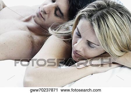 Close-up of a mid adult couple sleeping on the bed View Large Photo Image Stock Image - Close-up of a mid adult couple sleeping on the bed. Fotosearch