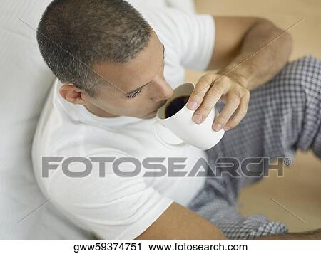 Stock Image - Close-up of a mid adult man drinking a cup of black tea. Fotosearch