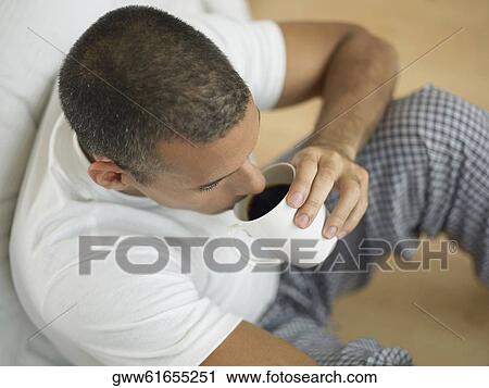 Stock Image - Close-up of a mid adult man drinking a cup of black tea. Fotosearch