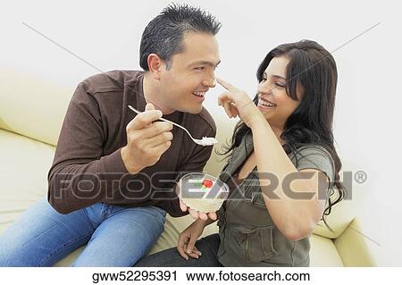 Close-up of a mid adult man feeding a young woman View Large Photo Image Stock Image - Close-up of a mid adult man feeding a young woman. Fotosearch
