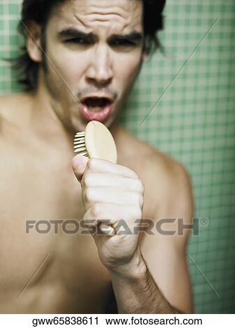 Close-up of a mid adult man holding a hairbrush and singing View Large Photo Image Stock Image - Close-up of a mid adult man holding a hairbrush and singing. Fotosearch