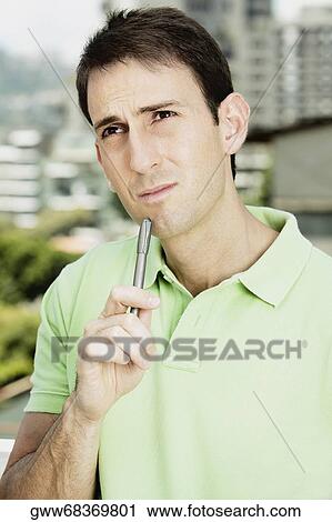 Close-up of a mid adult man holding a pen and a file View Large Photo Image Stock Image - Close-up of a mid adult man holding a pen and a file. Fotosearch