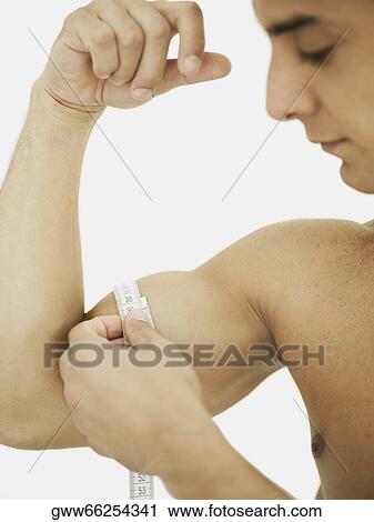 Close-up of a mid adult man measuring his biceps with a tape measure View Large Photo Image Stock Image - Close-up of a mid adult man measuring his biceps with a tape measure. Fotosearch