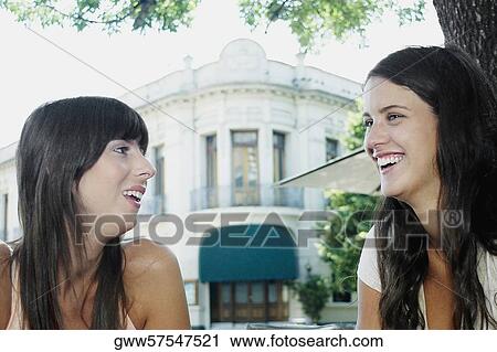 Close-up of a mid adult woman and young woman smiling and talking View Large Photo Image Stock Image - Close-up of a mid adult woman and young woman smiling and talking. Fotosearch