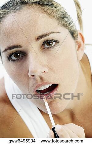 Close-up of a mid adult woman applying lip liner on her lips View Large Photo Image Stock Image - Close-up of a mid adult woman applying lip liner on her lips. Fotosearch