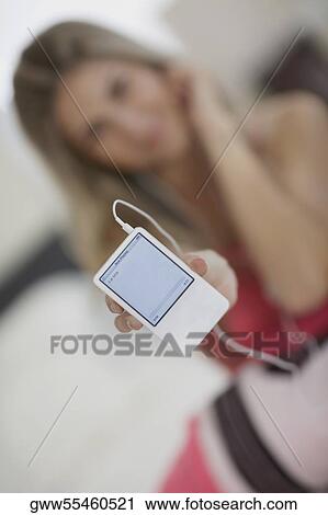 Stock Image - Close-up of a mid adult woman showing an MP3 player. Fotosearch