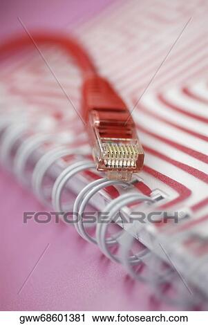 Stock Image - Close-up of a network connection plug on a spiral notebook. Fotosearch