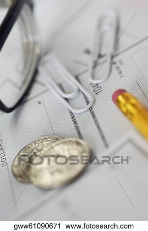 Close-up of a pair of eyeglasses with paper clips and coins on a check View Large Photo Image Stock Image - Close-up of a pair of eyeglasses with paper clips and coins on a check. Fotosearch