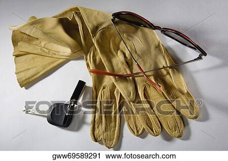 Stock Image - Close-up of a pair of sunglasses and gloves. Fotosearch