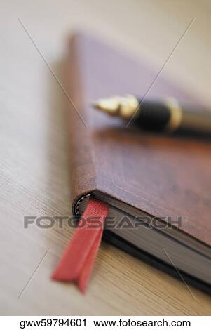Close-up of a pen and a diary on the table View Large Photo Image Stock Image - Close-up of a pen and a diary on the table. Fotosearch