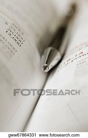 Stock Image - Close-up of a pen in an opened book. Fotosearch