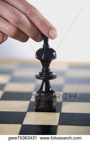 Close-up of a person's finger holding a chess piece View Large Photo Image Stock Image - Close-up of a person's finger holding a chess piece. Fotosearch