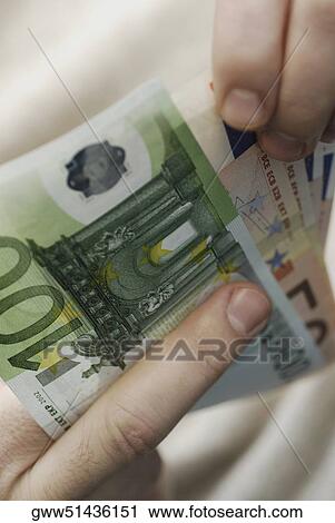 Close-up of a person's hand counting Euro banknotes View Large Photo Image Stock Image - Close-up of a person's hand counting Euro banknotes. Fotosearch