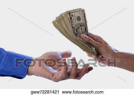 Stock Image - Close-up of a person's hand giving dollars to another. Fotosearch