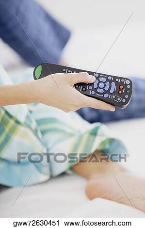 Close-up of a person's hand holding a remote control View Large Photo Image Stock Image - Close-up of a person's hand holding a remote control. Fotosearch