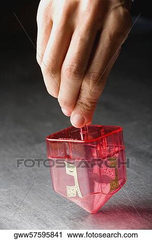 Stock Image - Close-up of a person's hand spinning a top. Fotosearch