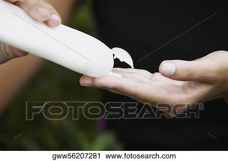 Close-up of a person's hand squeezing a bottle of moisturizer View Large Photo Image Stock Image - Close-up of a person's hand squeezing a bottle of moisturizer. Fotosearch