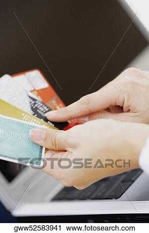 Close-up of a person's hands holding credit cards View Large Photo Image Stock Image - Close-up of a person's hands holding credit cards. Fotosearch