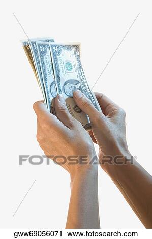 Stock Image - Close-up of a person's hands holding two dollar bills. Fotosearch