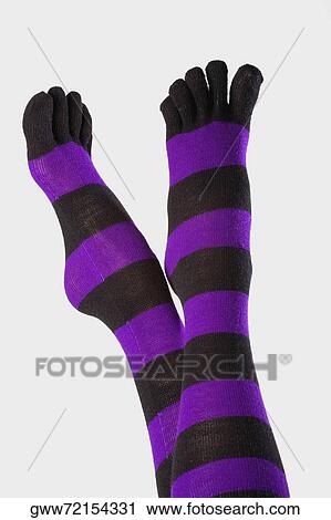 Stock Image - Close-up of a person's legs wearing socks. Fotosearch